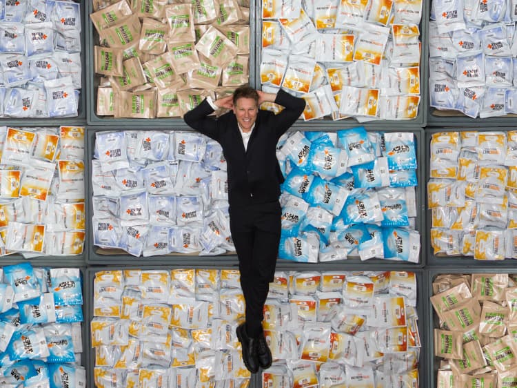 Ben Crowley lying on tubs of products