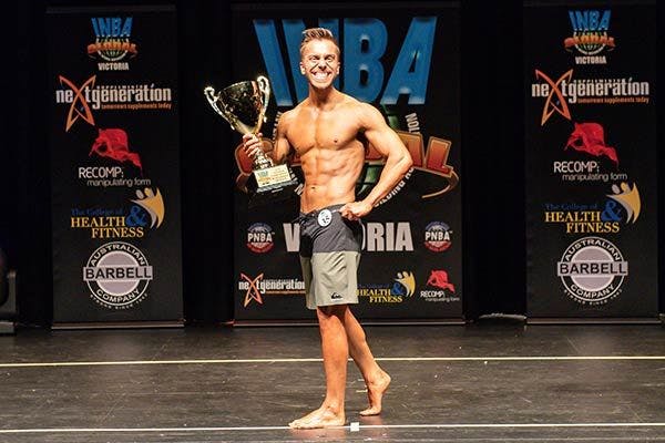 It's all smiles on stage as Bulk Ambassador Trent Baynes wins his first INCA VIC Men's Fitness Division trophy.