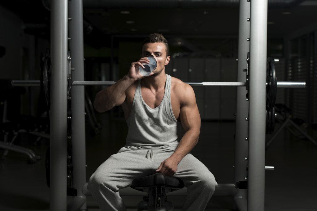 male-drinking-shake-gym-smith-machine