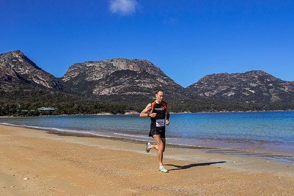Sponsored Bulk Athlete Chris Sullivan running the Freycinet beach in Tasmania.